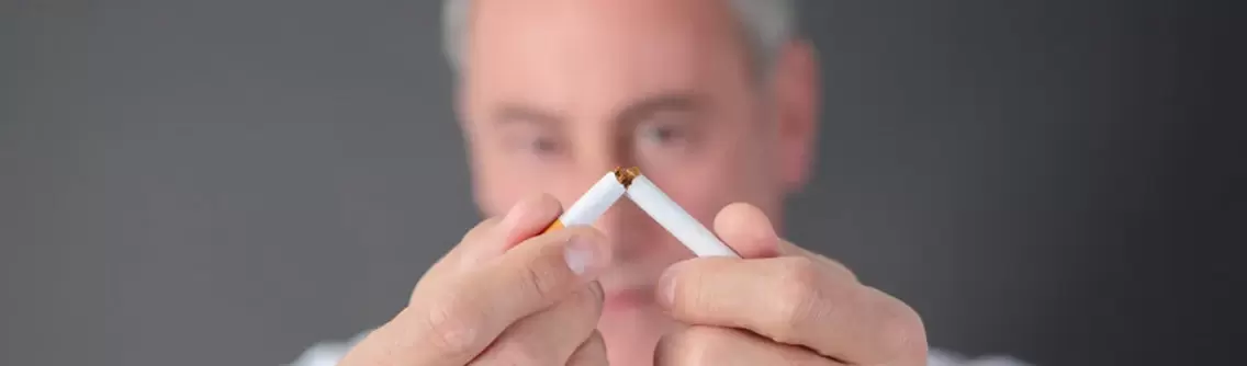 Mann zerbricht eine Zigarette
